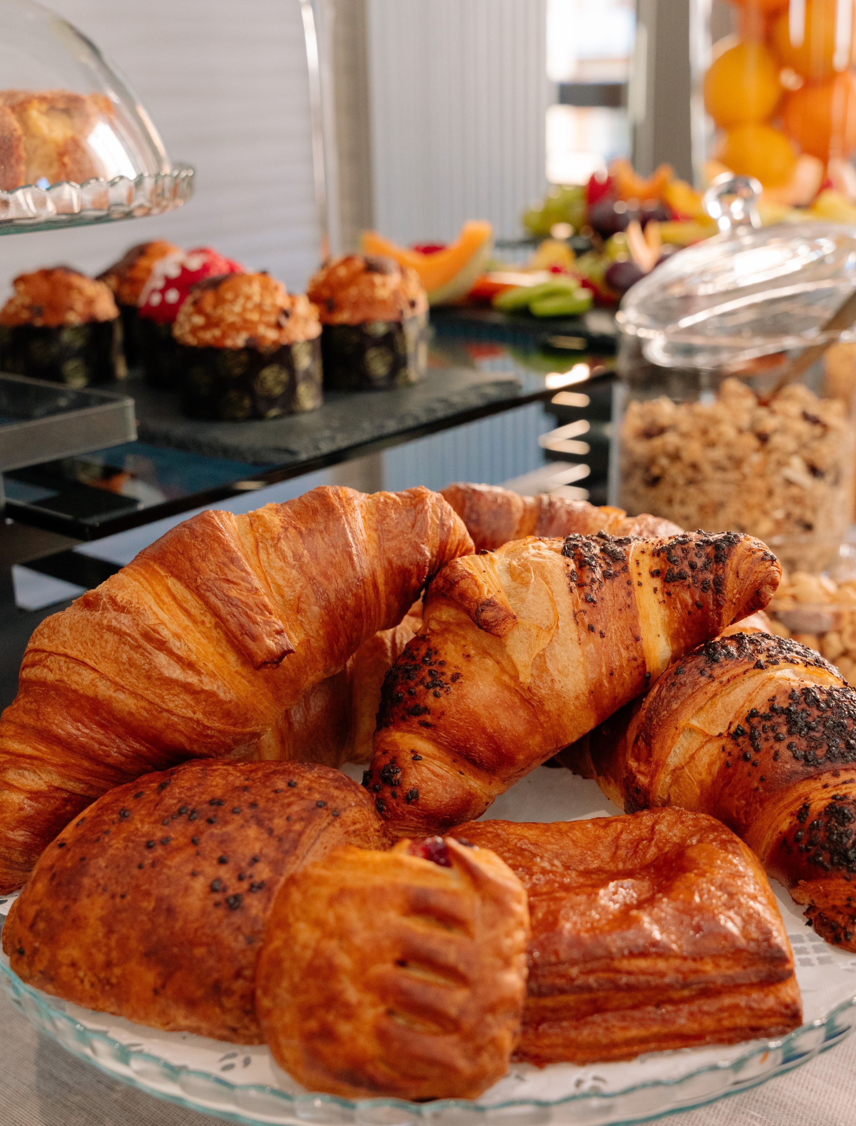 A glass display case with pastries and a variety of baked goods.