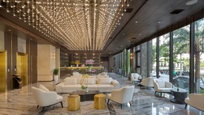 A spacious lobby with a marble floor, white sofas, and a ceiling with hanging lights. - Golden Lotus Grand (Da Nang)