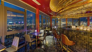 A modern bar with a city view, marble flooring, and contemporary furniture. - Golden Lotus Grand (Da Nang)