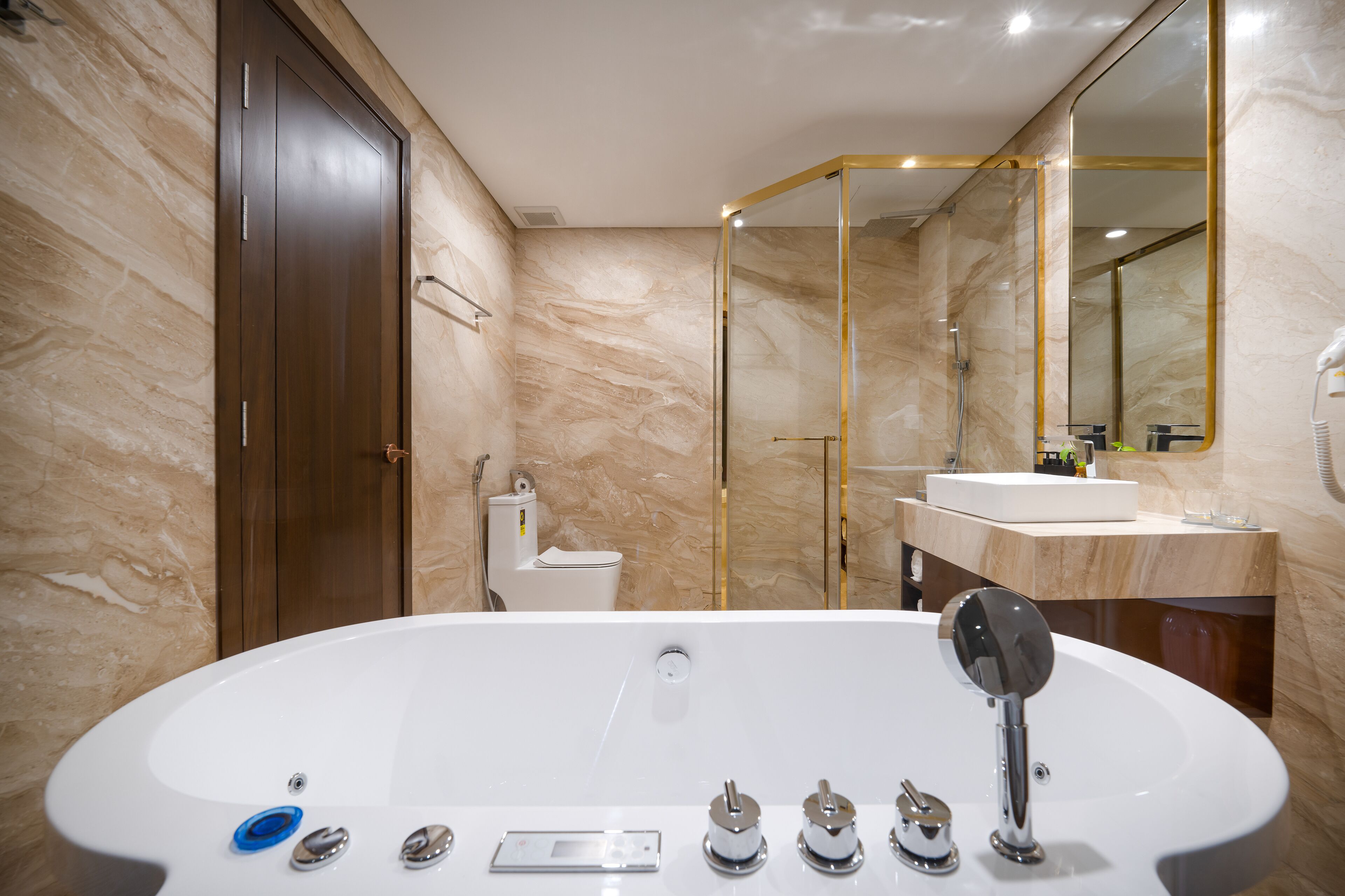 A modern bathroom with a freestanding bathtub, a toilet, a sink, and a large mirror.