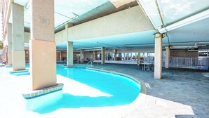En utomhuspool med betongpelare, ett överbyggt område och ett kaklat poolområde.