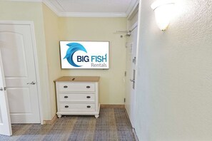 A hallway with a white door, a white dresser, and a wall-mounted sign for Big Fish Rentals.