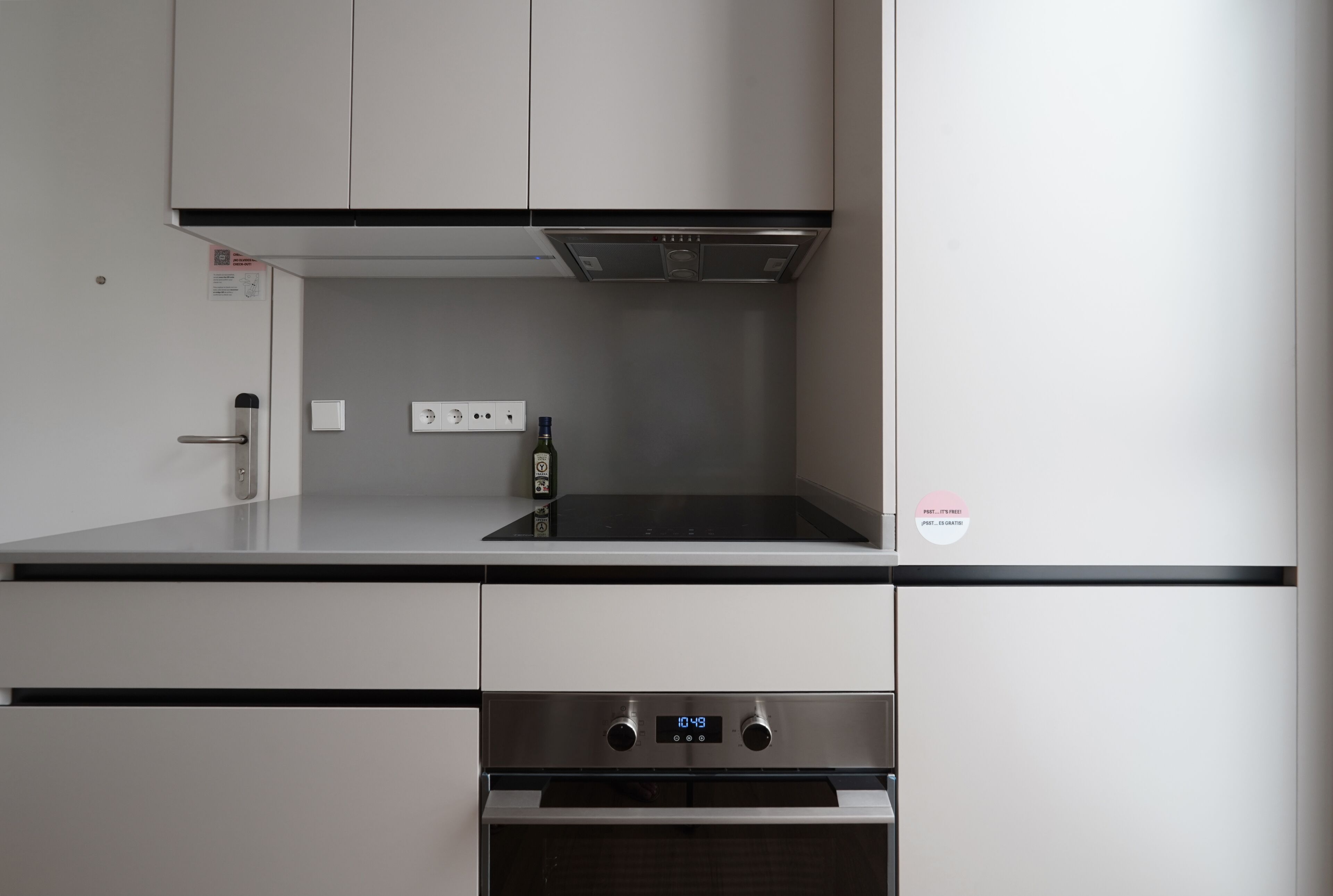 Una cucina moderna con forno integrato e cappa aspirante in acciaio inossidabile.