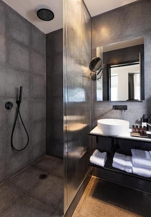 A modern bathroom with a glass-enclosed shower, a white sink, and a mirror above it. - Brut Seafront Hotel By Sunday (Tel Aviv)
