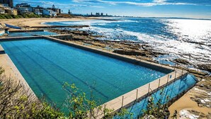 A swimming pool with a view of the ocean and beach. - Bay House Motel (Bateau Bay)