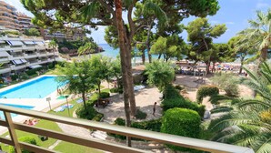 Un complexe hôtelier doté d’une piscine, d’un espace plage et d’une végétation luxuriante.