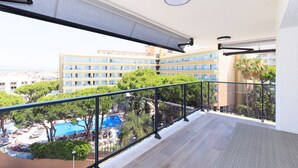 Un balcó amb vista a una piscina i un edifici de diversos pisos.