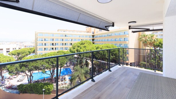 Un balcon donnant sur une piscine et un immeuble à plusieurs étages.