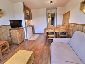 A compact living space with a kitchenette, a dining area, and a seating area.