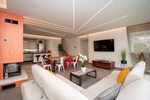 A modern living room with a sofa, coffee table, and dining area.