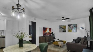 A modern living room with a dining area, a fireplace, and artwork on the walls.