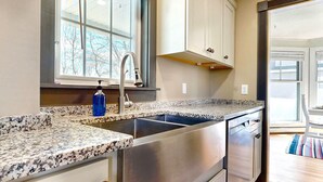 A kitchen with granite countertops, stainless steel appliances, and white cabinetry. - Dancing Queen by Bayley Vacation Rentals (Old Orchard Beach)
