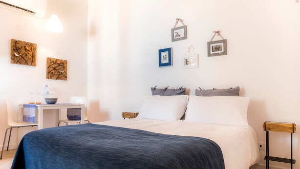 Ein Schlafzimmer mit einem großen Bett, einem Schreibtisch mit Stuhl und einem kleinen Tisch.