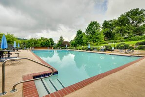 A swimming pool with a red-tiled edge, surrounded by lounge chairs and umbrellas. - Serene Sky Valley Family Chalet w/ Fireplace (Sky Valley)