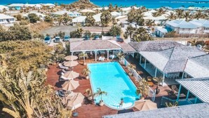 A resort with a central swimming pool, multiple lounge areas, and a view of the ocean. - Front line unit 520 ft2 on 2nd floor facing ocean (Orient Bay)