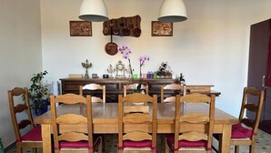 A dining area with a wooden table and six chairs, a chandelier, and wall-mounted decorative items. - Maison de Maître Gironde built in 1896 and fully restored (saint philippe d'aiguille)