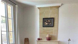 A room with a fireplace, two red armchairs, a small round table, and a wooden dresser. - Maison de Maître Gironde built in 1896 and fully restored (saint philippe d'aiguille)