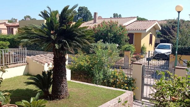 A residential area with houses, a palm tree, and a car parked in the driveway. - Sicicas, 300 meters from the sea, 5 minutes walk (Villasimius)