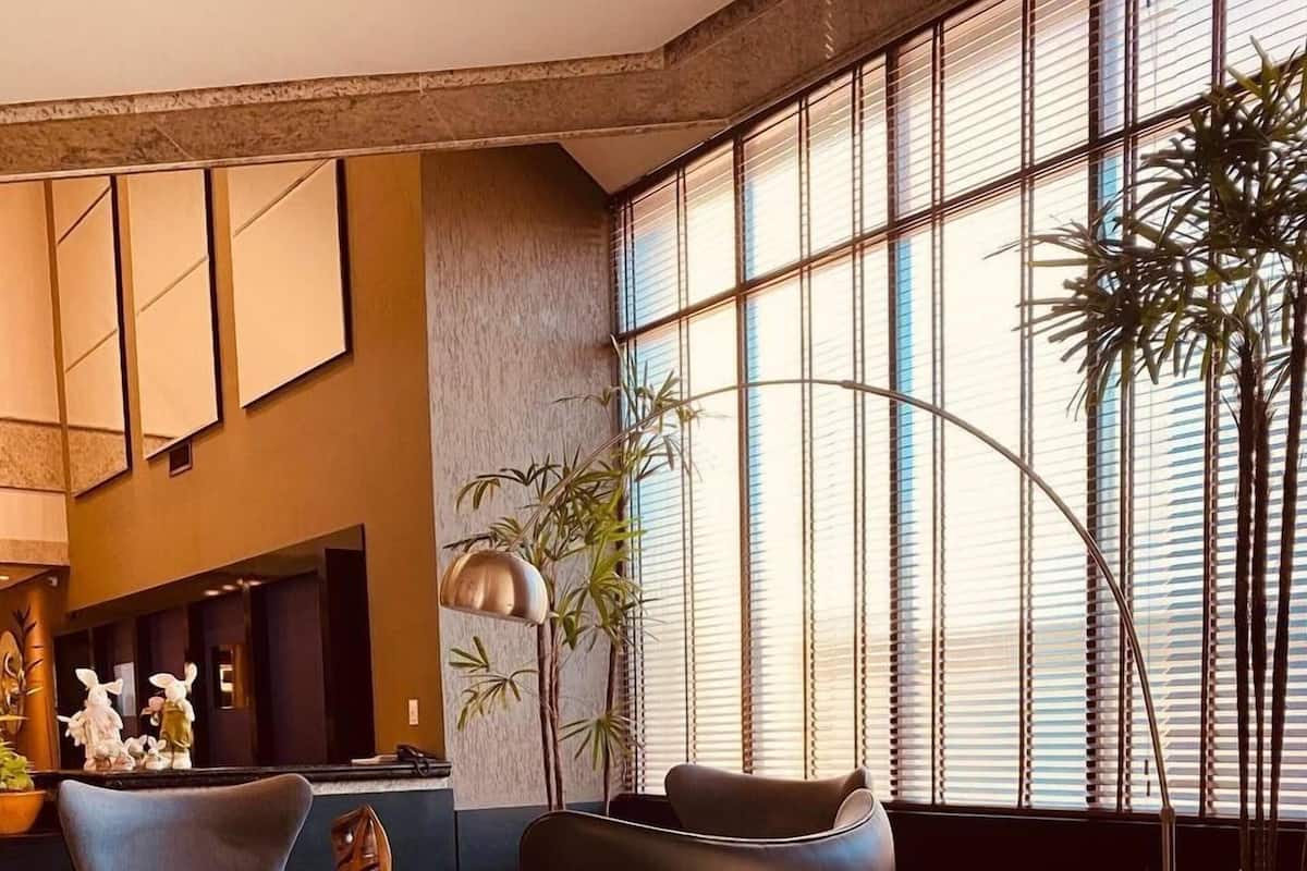 A modern lobby with a curved seating area, large windows, and a reception desk.