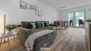 A modern living room with a sofa, coffee table, and a dining area.