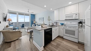 A modern kitchen with white cabinets, a built-in oven, and a dishwasher. - Gulf Front Views | Indoor & Outdoor Pools, Hot Tub, Sauna, & Fitness Center (Gulf Shores)