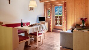 Un intérieur en bois comprenant une table à manger, des chaises, un téléviseur et un canapé.