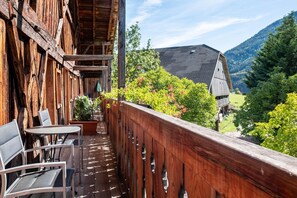 A wooden balcony with a view of a mountain, a table, and chairs. - Apartment "Birke - Fiechterhof" with Shared Open Terrace, Garden & Wi-Fi (Sarentino)