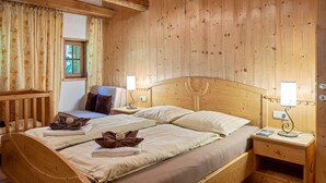 Une pièce en bois avec deux lits, une fenêtre et une table de chevet avec une lampe.