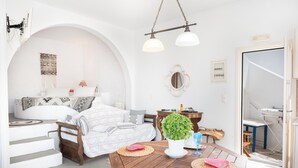 Una sala moderna con un sofá, una mesa de comedor y una planta en maceta.