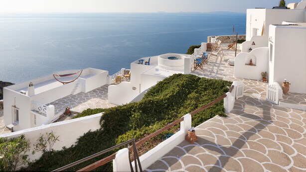 Un edificio blanco con vistas al mar, terraza al aire libre y jardín.