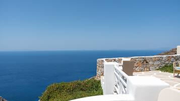 Une vue sur la côte, avec un mur de pierre et une balustrade blanche surplombant la mer.