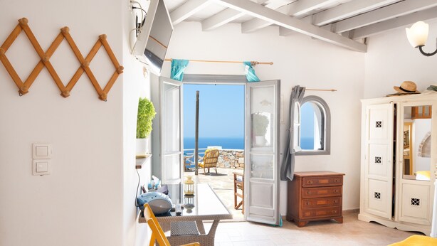 Une chambre avec vue sur la mer, un coin repas et une armoire.