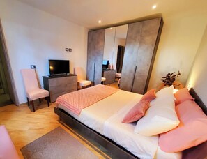 A modern bedroom with a bed, a TV, a dresser, and a chair. - Villa 'Tore' with Sea View, Wi-Fi, and Air Conditioning (Quartu Sant'Elena)