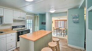 A kitchen with white cabinets, a wooden countertop, and a bar stool area. - Peaceful Satsuma Escape w/ Dunns Creek Access (Satsuma)