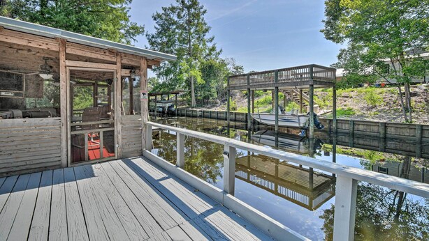 A wooden deck with a glass enclosure, a wooden bridge over a water body, and a covered area with a railing. - Peaceful Satsuma Escape w/ Dunns Creek Access (Satsuma)