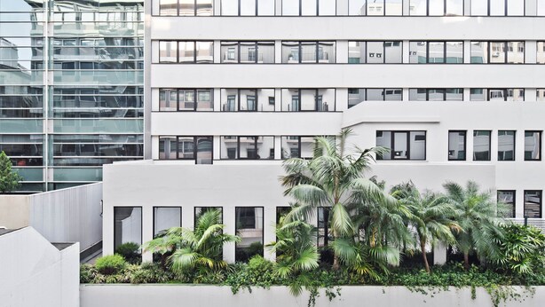 A modern building with multiple floors, large windows, and a rooftop garden with palm trees. - Av. Liberdade 4 - Duque de Palmela (Lisbon)