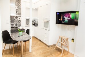 Enjoy meals in the kitchen with a flat-screen TV and dining area featuring a round table and comfortable seating.