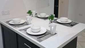 Een moderne keuken met een centraal eiland, zwarte kastjes en een wit aanrecht.