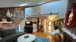 Uma sala de estar moderna com televisão de tela plana, um sofá cinza, uma mesa de centro e um tapete estampado.