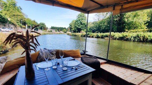 Een gedekte tafel met uitzicht op een rivier en groen.