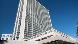 Un grand bâtiment d’hôtel moderne, doté d’une façade à balcons et d’une galerie couverte à sa base.
