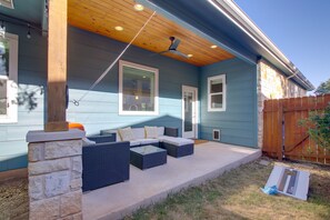 A covered patio with outdoor furniture, a ceiling fan, and a stone pillar. - Modern Lago Vista Home w/ Pool & Lake Access! (Lago Vista)