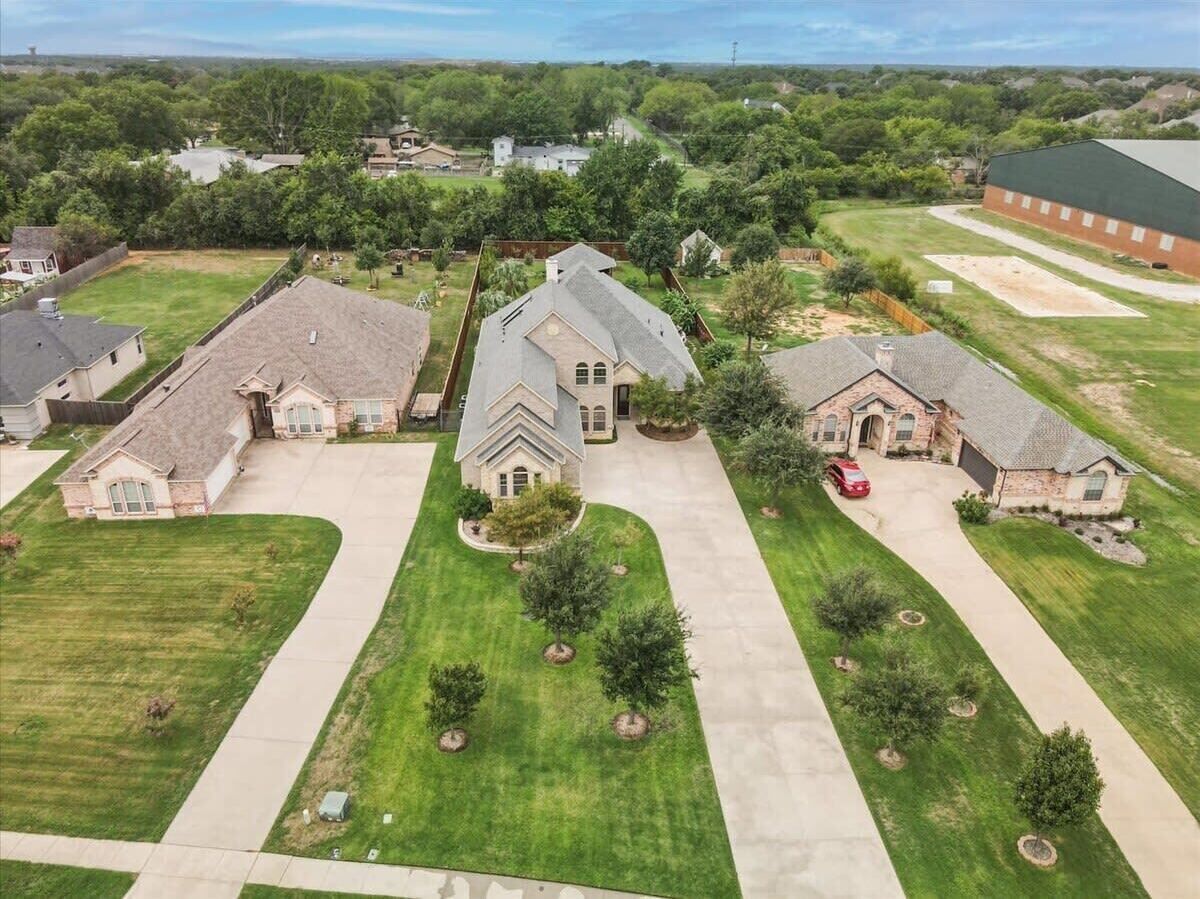 A residential area with houses, lawns, and a driveway.