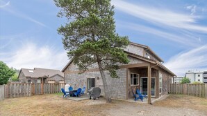 A single-story house with a covered patio area, a barbecue grill, and blue patio chairs. - Close to beach, Discovery Trail, Fenced Yard (Seag) (Long Beach)