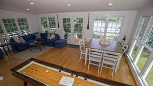 A pool table in a spacious living area with a blue sofa, dining table, and chairs. - Sunset Cottage on Badin Lake, NC! (New London)