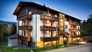 Ein mehrstöckiges Hotel mit Balkonen, einer Stein-Fassade und einem Schild, das es als Restaurant kennzeichnet.