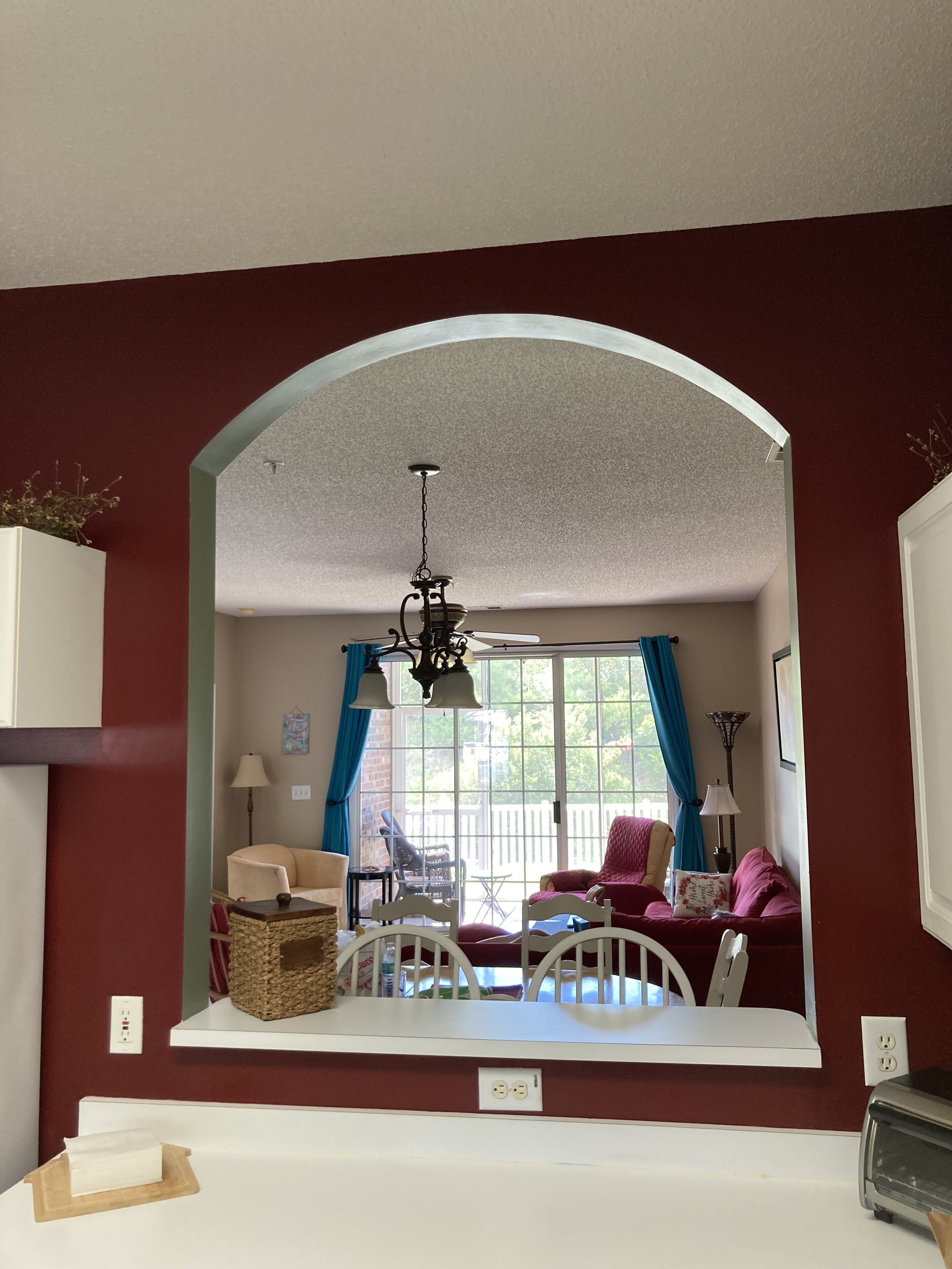 A dining area with a white table, chairs, and a hanging light fixture.