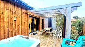 A wooden deck with a hot tub, a table, and chairs, and a pergola structure. - Les Bord'Océanes Villa Marensine and Villa Oyat – Private Sauna & Spa (Vielle-Saint-Girons)