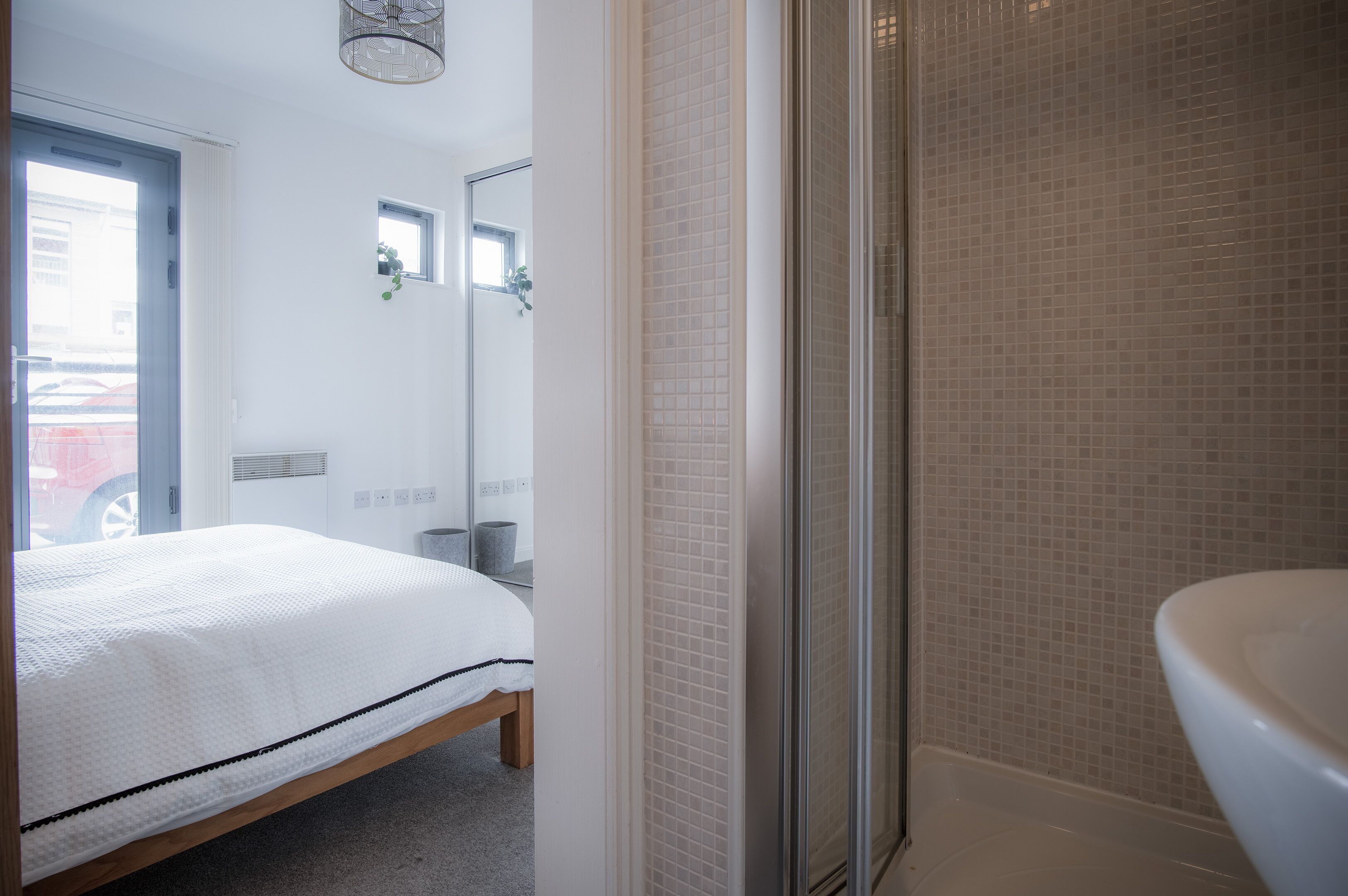 Ein Schlafzimmer mit Bett, ein Badezimmer mit Dusche und Toilette.
