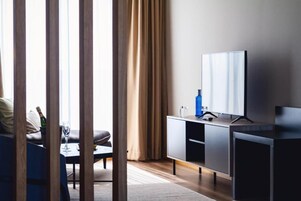 A modern living room with a sofa, a coffee table, a television on a stand, and a cabinet.